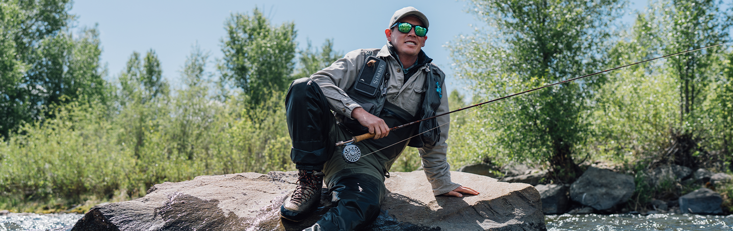 man wearing prescription sunglasses while fishing in a river