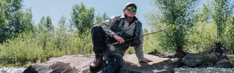 man wearing prescription sunglasses while fishing in a river