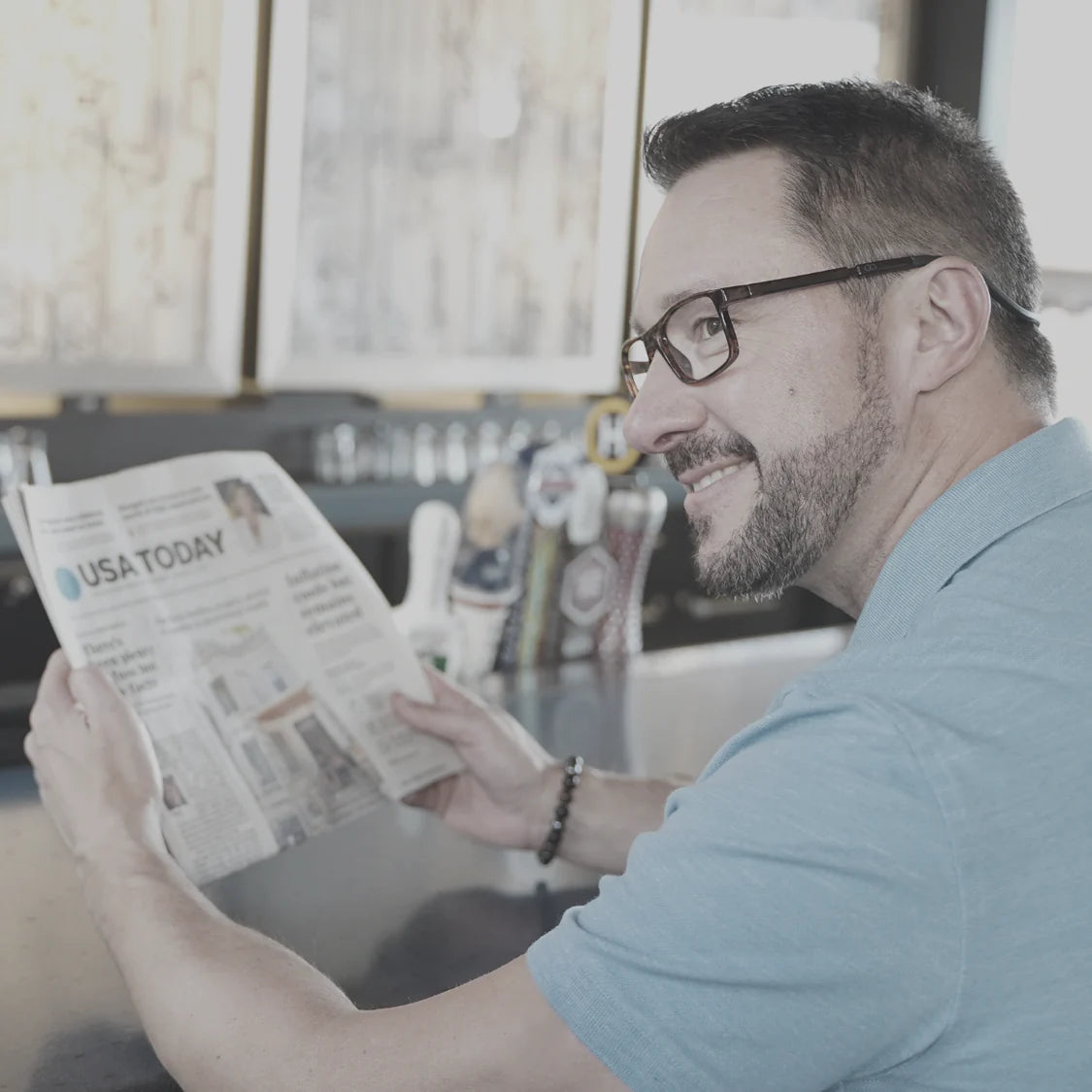 Man with CliC Readers looking at the newspaper