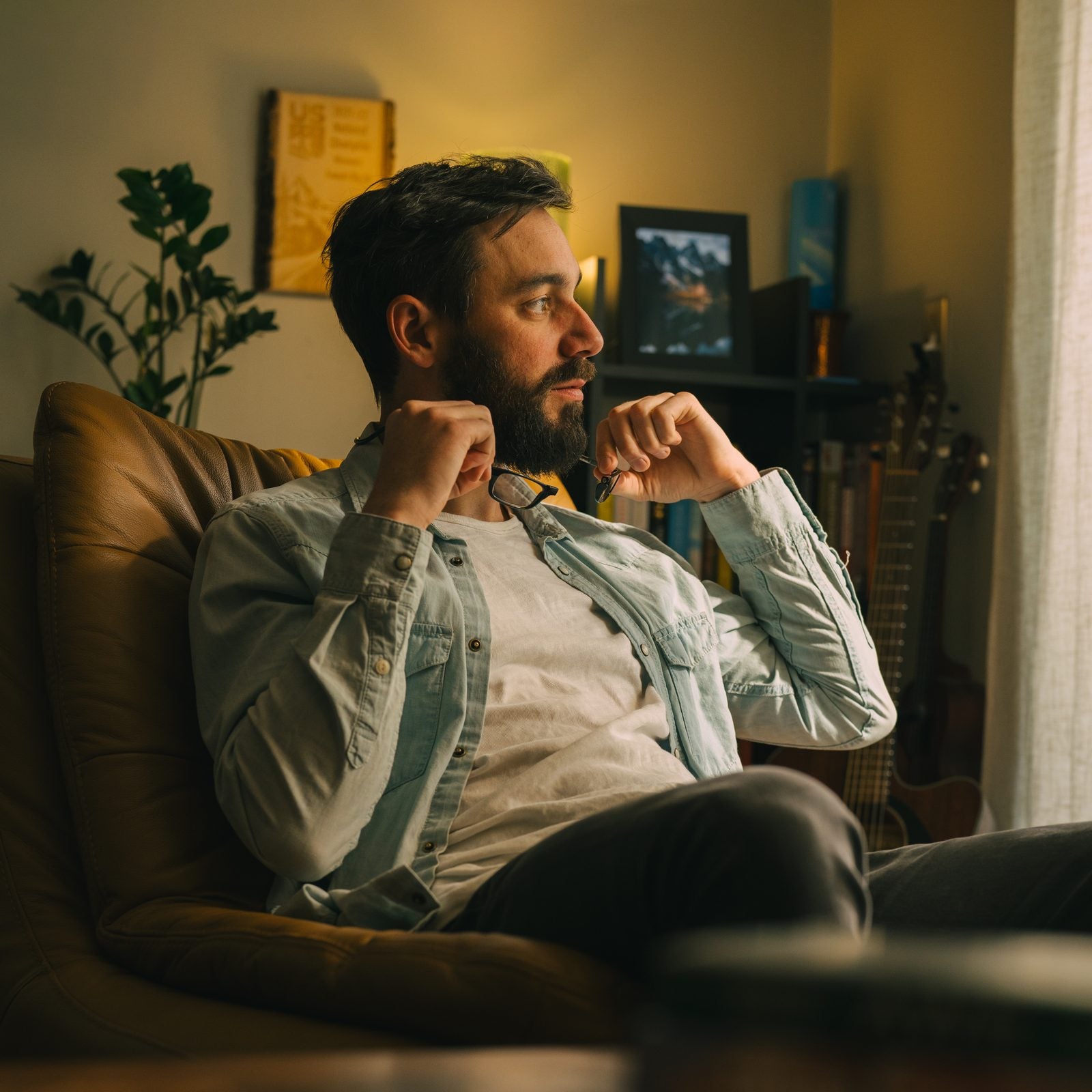 Man relaxing in a leather chair holding CliC readers at his collar